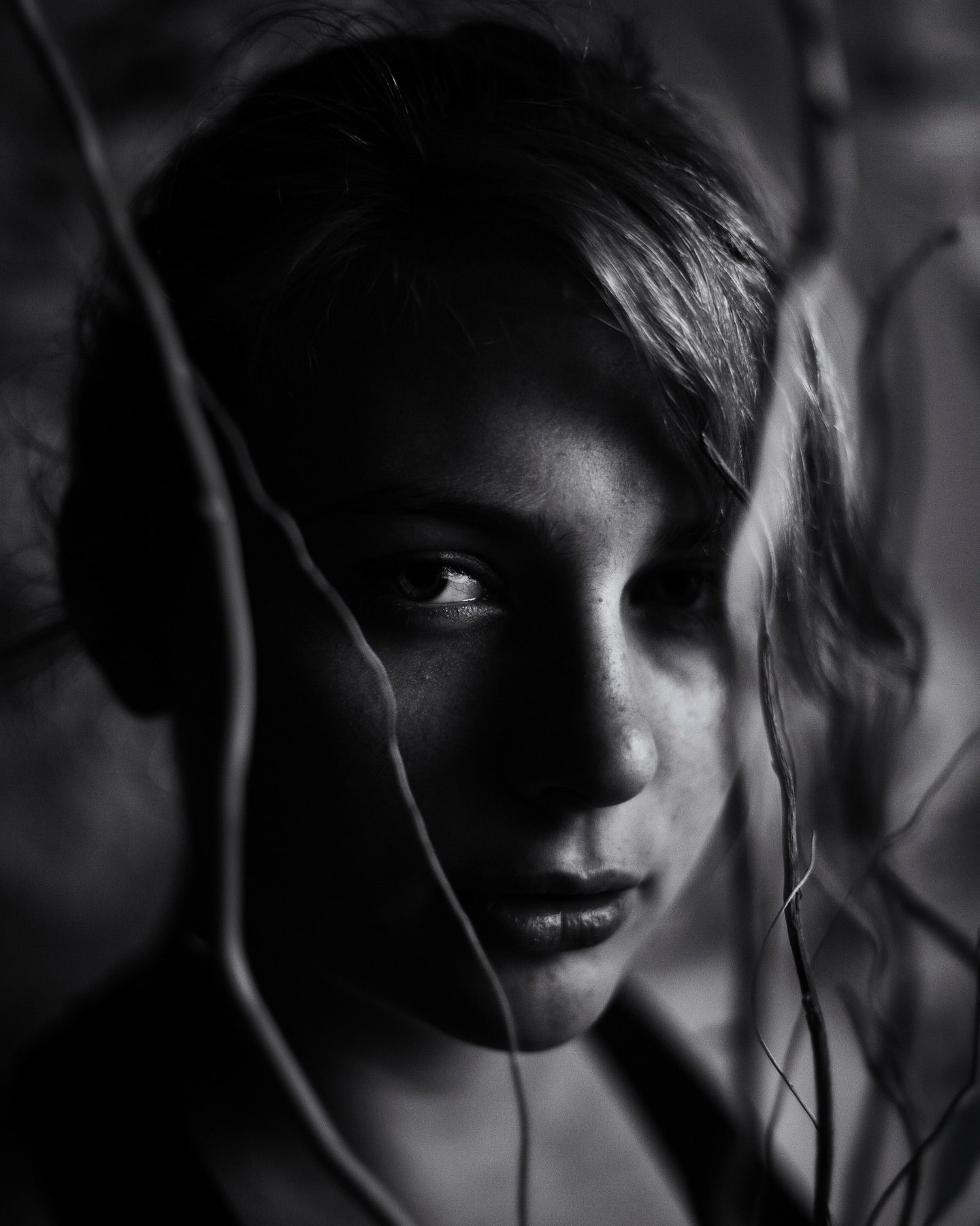 Dark dramatic portrait through vines